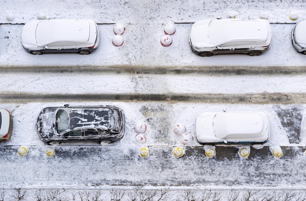 Os carros de passageiros estacionados e montes de neve de neve no quintal na rua de inverno