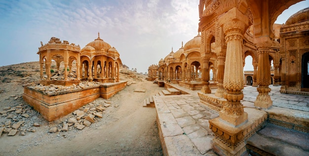 Os cenotáfios reais de governantes históricos, também conhecidos como Jaisalmer Chhatris, em Bada Bagh em Jaisalmer, Rajasthan, Índia. Cenotáfios feitos de arenito amarelo ao pôr do sol