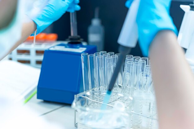 Os cientistas asiáticos injetaram produtos químicos em tubos de plásticoCientista da Tailândia trabalhando no LabExperiment no laboratório