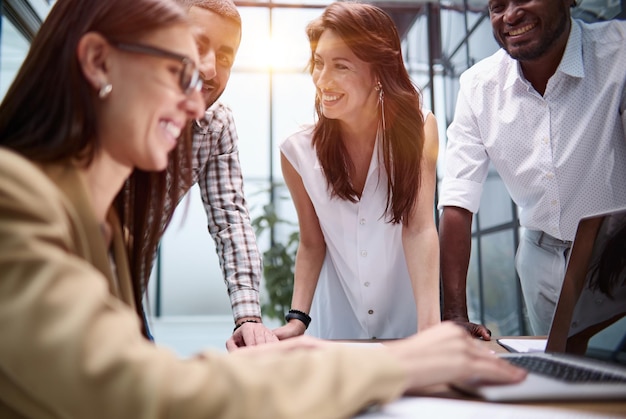 Os colegas se apoiam na mesa de conferência e discutem a interface do usuário e o design do aplicativo de negócios