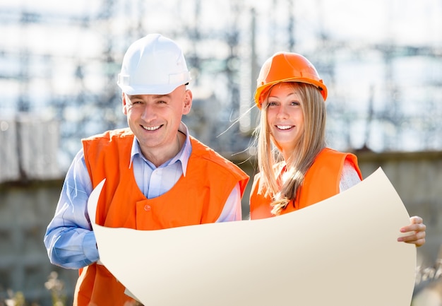 Os construtores estão rindo segurando um lençol branco de