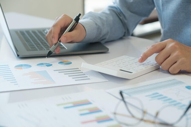 Foto os contabilistas estão a usar calculadoras para calcular os rendimentos, as despesas e os investimentos.