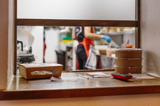 Foto os cozinheiros de um restaurante preparam comida para levar. os recipientes usados são compostáveis.