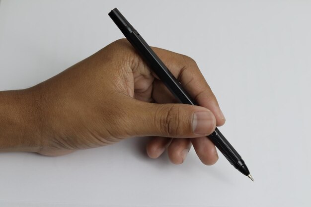 Os dedos do povo indonésio em um fundo branco estão segurando uma caneta