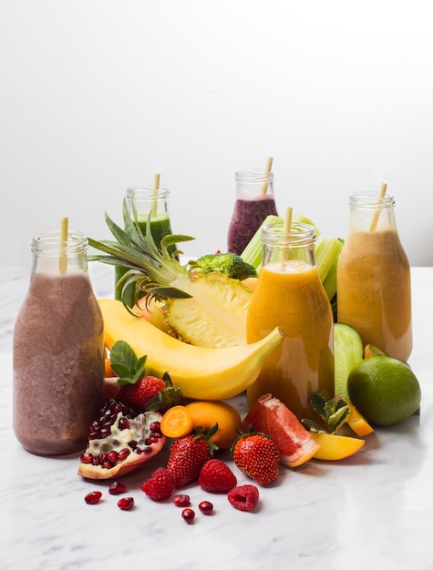 Os deliciosos smoothies com frutas exóticas em um fundo branco