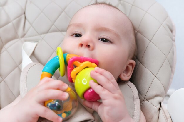 Foto os dentes de leite do bebê estão explodindo, as gengivas coçam. a criança tem um brinquedo na boca