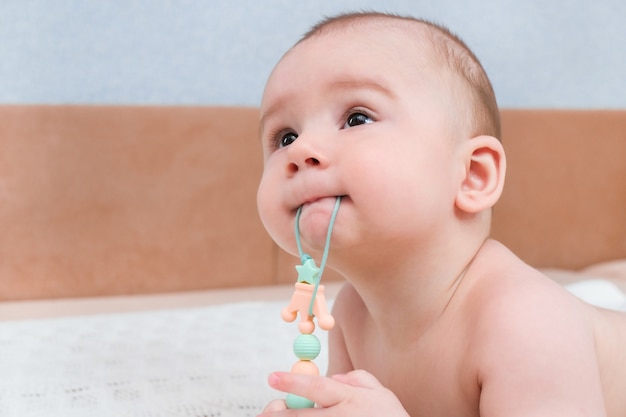 Os dentes de leite do bebê estão explodindo, as gengivas coçam. a criança tem um brinquedo na boca