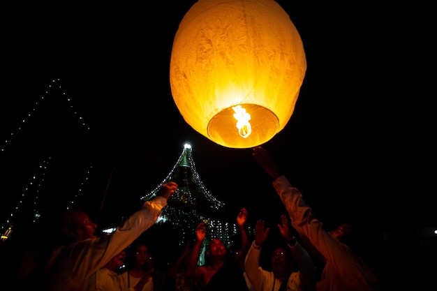 Os devotos budistas estão tentando voar lanternas de papel nas occas