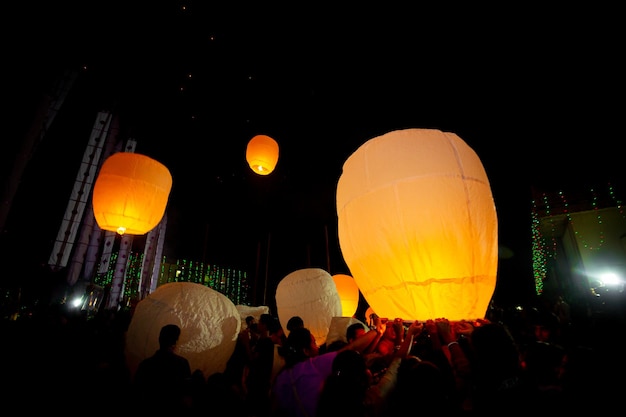 Foto os devotos budistas lançaram lanternas de papel gigantes no céu noturno.