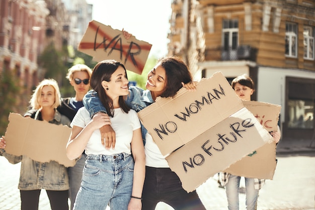 Os direitos das mulheres são direitos humanos, duas jovens felizes segurando cartazes e sorrindo