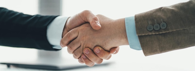 Foto os dois homens apertando a mão acima da mesa