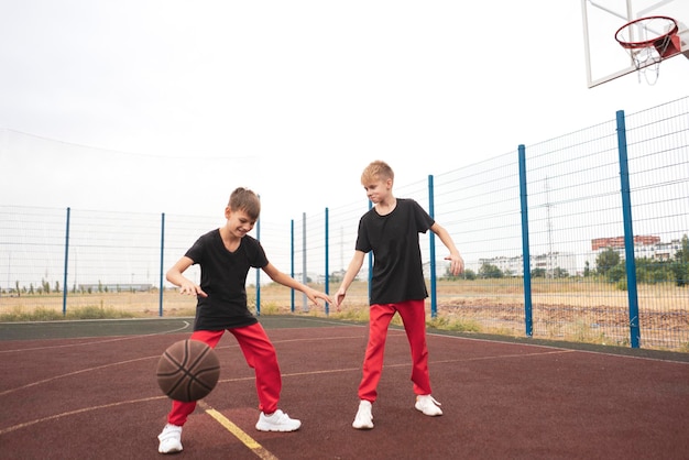 Os dois meninos jogando basquete 1 contra 1 ao ar livre