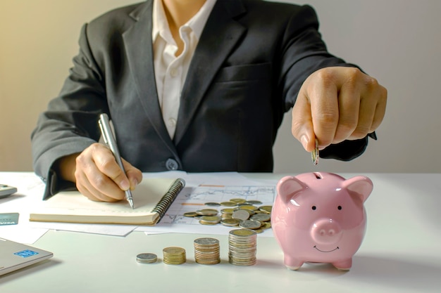 Os empresários estão colocando moedas em uma jarra de poupança, incluindo um centavo crescente para ideias de negócios, finanças e contabilidade.