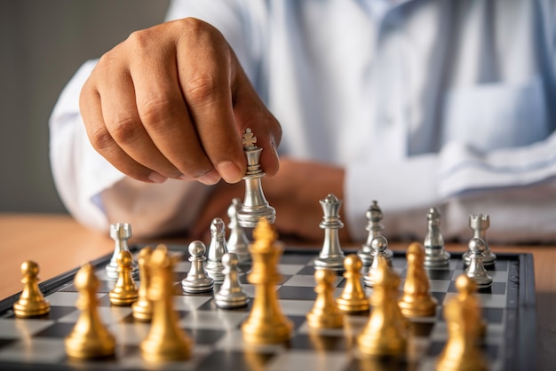 Pessoa jogando jogo de tabuleiro de xadrez, imagem conceitual de empresária  segurando peças de xadrez contra adversário de xadrez contra competição de  negócios, planejando estratégias de negócios para derrotar concorrentes de  negócios