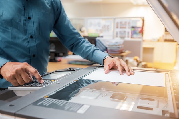Foto os empresários pressionam o botão no painel para usar fotocopiadora ou impressora para imprimir e digitalizar papel de documento no escritório.