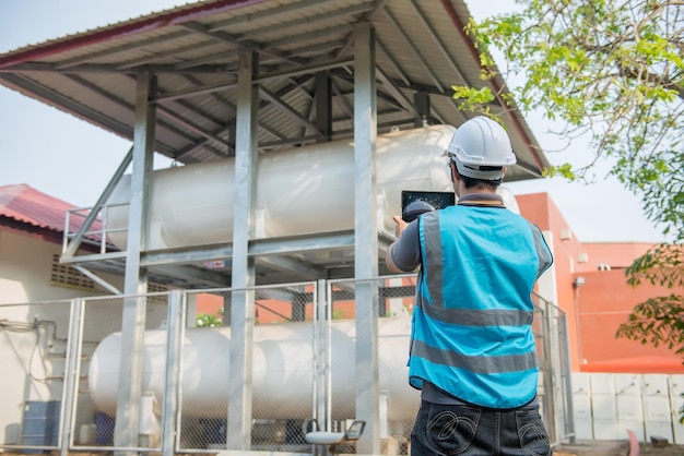 Os engenheiros trabalham no local para manter o cronograma de manutenção preventiva de hélio líquido, verificando o povo da tailândia