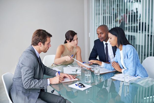 Os estrategistas de negócios Foto de um grupo de empresários revisando documentos durante uma reunião
