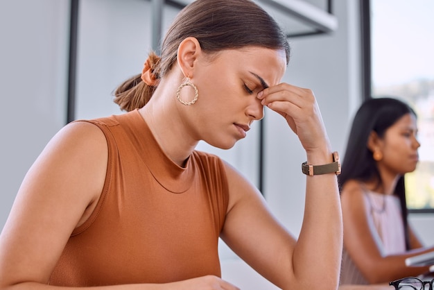 Foto os exames são estressantes foto de uma jovem empresária com dor em um escritório