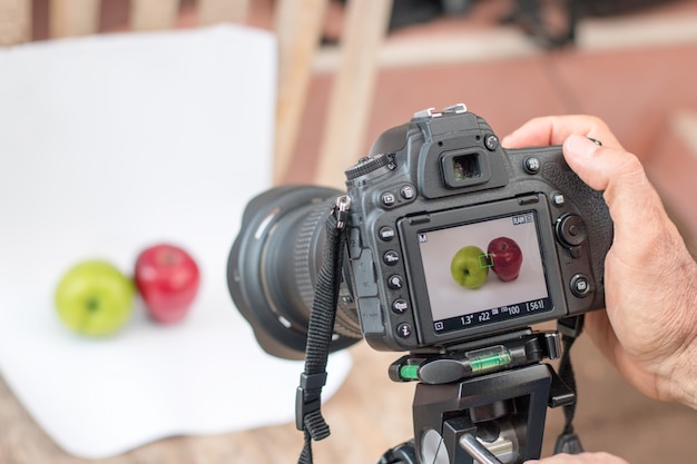 Os fotÃ³grafos estÃ £ o usando dslr camera shooting fruit on white