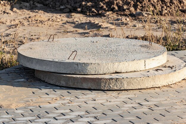 Os fundos do poço de concreto armado e do esgoto ficam ao ar livre produtos de concreto armado no canteiro de obras instalações de produção industrial para poços de esgoto