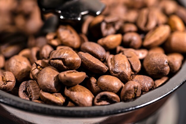 Os grãos de café fritos estão em um moedor de café. o café árabe é rezado em um moedor de café mecânico. café da manhã.