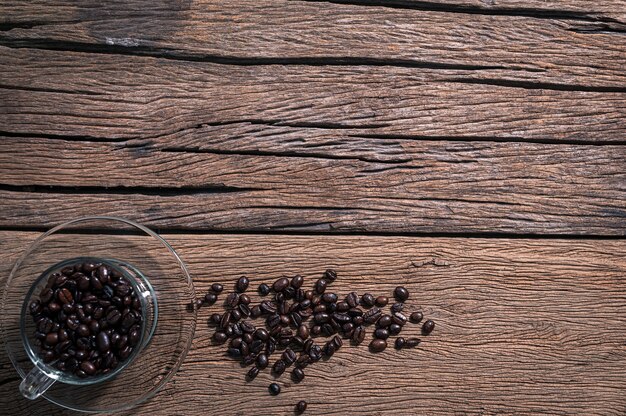 Os grãos de café na xícara são colocados na vista de cima da mesa