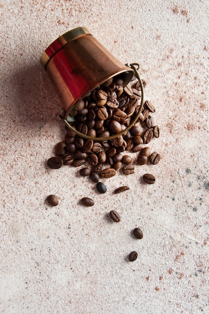 Os grãos de café são derramados de um balde de cobre