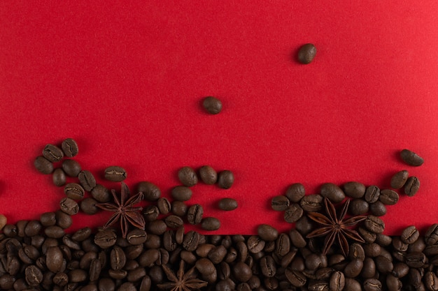 Os grãos de café são espalhados em um close de papel vermelho, copyspace comercial.