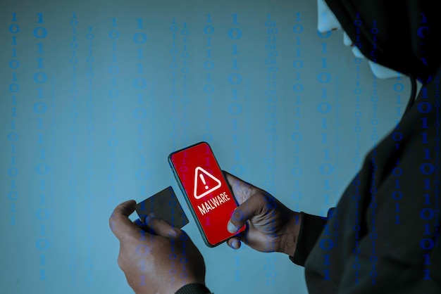 Os hackers de capuz estão usando o celular para atacar dados confidenciais no código binário de fundo do cartão de crédito Hacking e conceito de malware