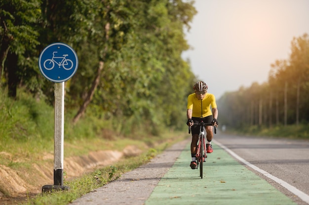 Os homens asiáticos estão andando de bicicleta de estrada pela manhã