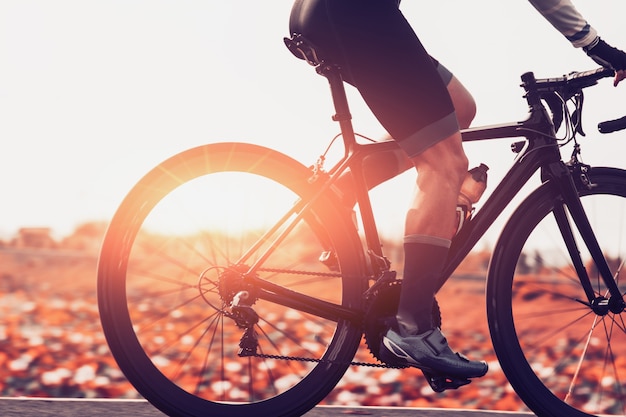 Os homens estão andando de bicicleta na estrada ao amanhecer.