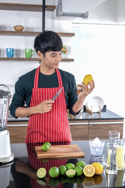 Os homens estão olhando as frutas de lemmon na cozinha.