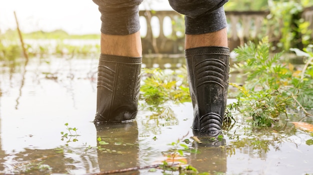 Os homens usam botas pretas para uma enchente