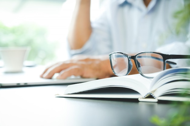 Os idosos trabalham duro, têm dor nos olhos Sentado no escritório Ele está estressado.