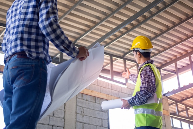 Os inspectores verificam a integridade da construção da casa. discuta métodos e resolva problemas de estrutura de construção com empreiteiros ou engenheiros.