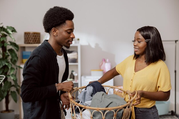 Os irmãos mais velhos fazem as tarefas domésticas juntos, separam a roupa suja, seguram a cesta de vime