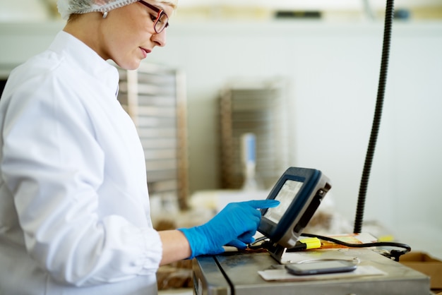 Os jovens concentraram a trabalhadora em panos estéreis, usando uma maquinaria complexa na linha de produção da fábrica.