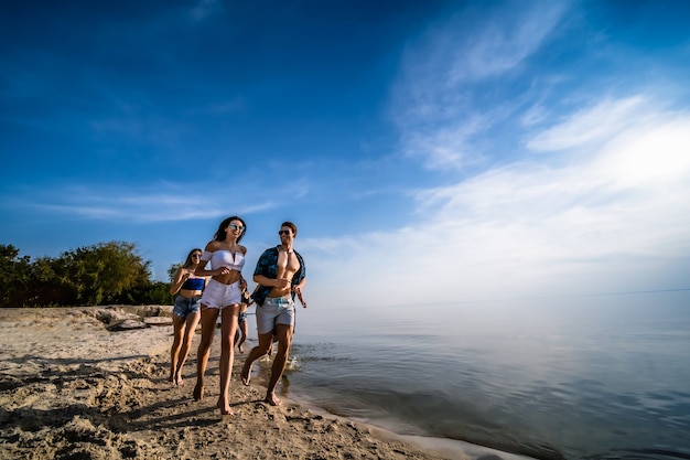 Os jovens correndo na praia