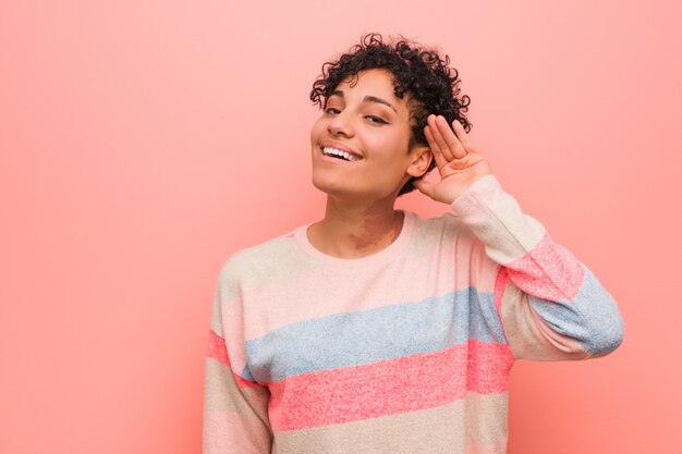 Os jovens misturaram a mulher afro-americano do adolescente que tenta escutar uma fofoca.