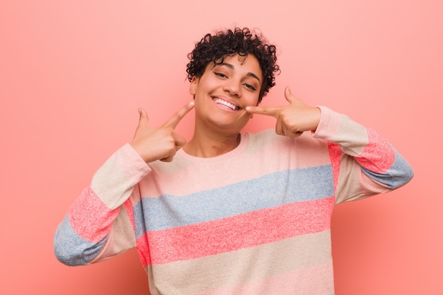 Os jovens misturaram os sorrisos afro-americanos da mulher do adolescente, apontando os dedos na boca.