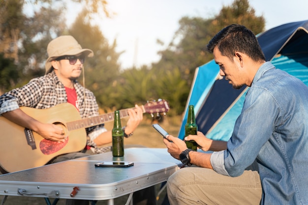 Os jovens vão acampar no verão no parque nacional com cerveja e uma pequena festa de violão. foto grátis