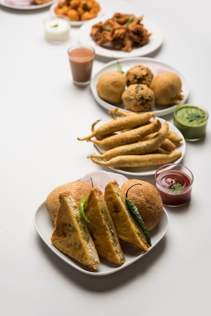 Os lanches da hora do chá indiano no grupo incluem Veg Samosa, Kachori, kachaudi, aloo bonda, khaman dhokla, pão, cebola, pimenta e moong pakora, pakoda, bhaji, bhajji, Bhajiya, bajji com molhos