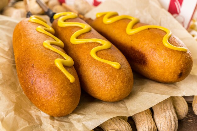 Foto os lanches tradicionais do dia do jogo incluíam corndogs e amendoins salgados em uma placa de madeira.