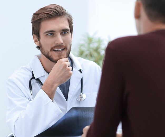 Foto os médicos discutem com o paciente o raio x