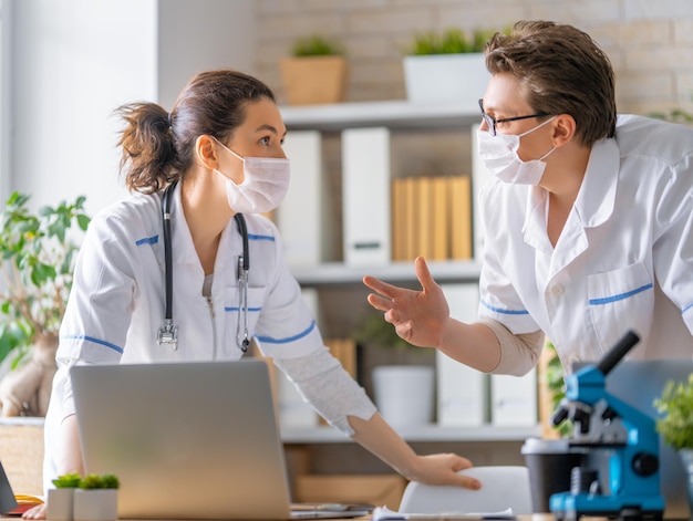 Os médicos estão conversando. As pessoas estão trabalhando no consultório médico.