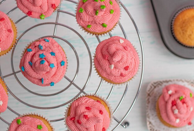 Foto os muffins flatley são decorados com creme rosa brilhante e decoração de açúcar