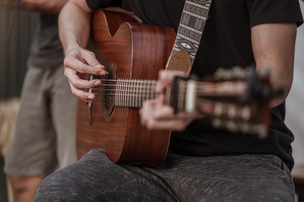 Os músicos estão checando o som do violão e tentando tocar violão antes do evento