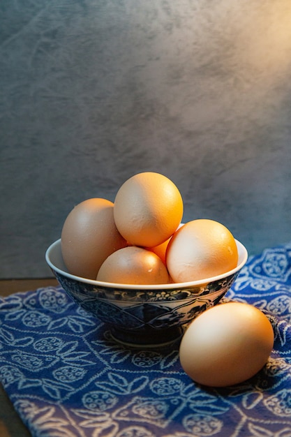 Os ovos na tigela na mesa de madeira para o conteúdo alimentar.