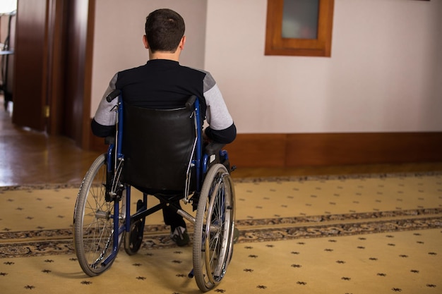 Os pacientes do homem sentam-se sozinhos em uma cadeira de rodas