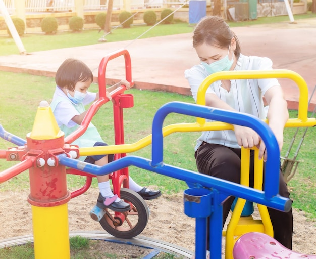 Os pais levam os alunos em uniformes escolares para atividades em família Brincar no equipamento do playground Passeios com bicicletas círculos e diversão para duas noites depois da escola